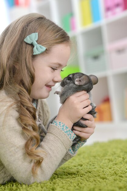 Petite fille mignonne jouant avec le chinchilla