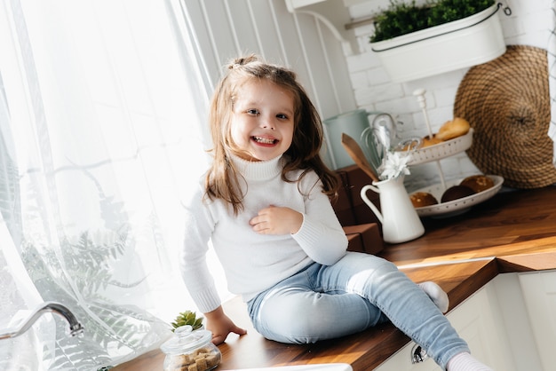 Petite fille mignonne jouant dans la cuisine, le bonheur, la famille. Cuisine.