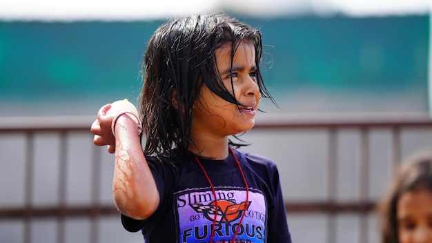 Une petite fille mignonne jouant avec de l'eau avec un ballon d'eau