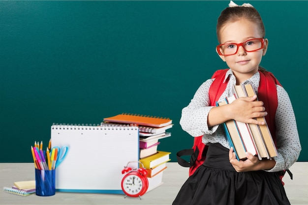 Petite fille mignonne avec des livres sur le fond