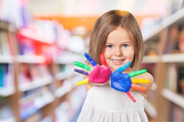 Petite fille mignonne avec des mains dans la peinture colorée