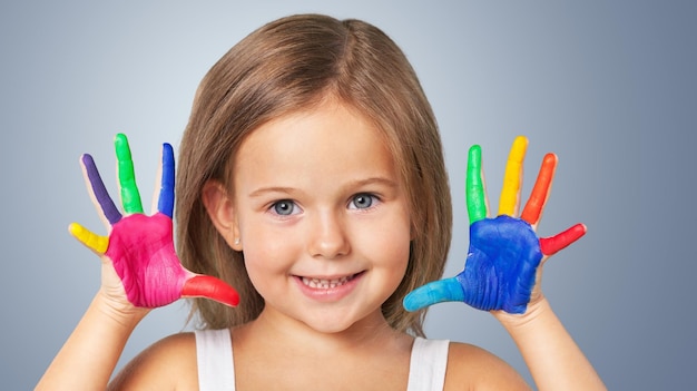 Petite fille mignonne avec les mains peintes colorées sur le fond