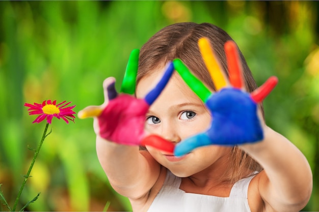 Petite fille mignonne avec les mains peintes colorées sur le fond