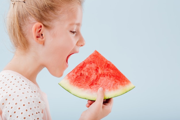 Petite fille mignonne mangeant une tranche de pastèque