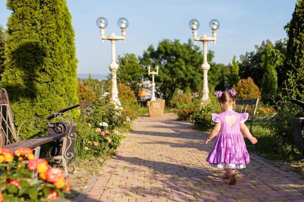 Petite fille mignonne marchant dans le parc d'été en plein air Concept d'enfance