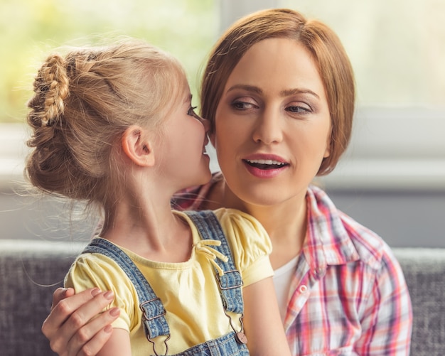 La Petite Fille Mignonne Murmure Quelque Chose Dans Sa Mère.