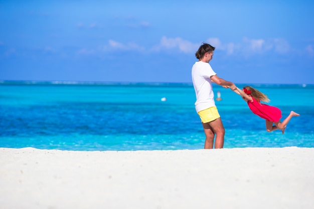 Petite fille mignonne et papa pendant les vacances à la plage tropicale