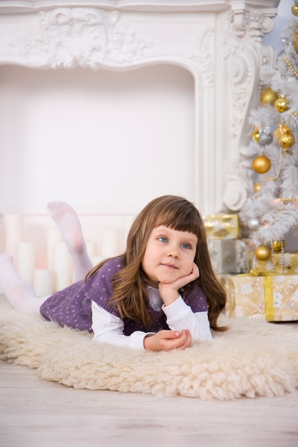 Petite fille mignonne près d'un arbre de Noël