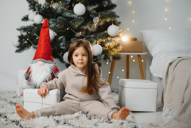 Petite fille mignonne près de l'arbre de Noël