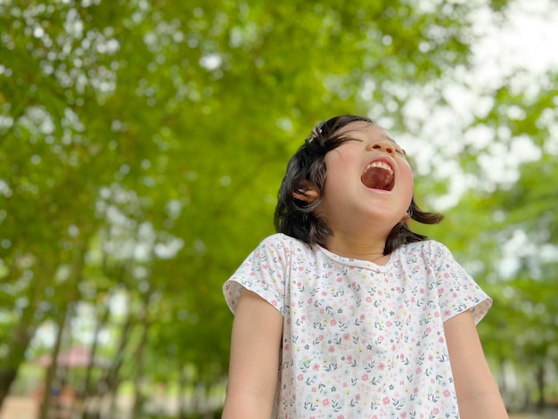 La petite fille mignonne rit dans le jardin