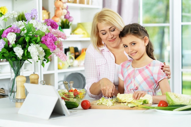 Petite fille mignonne avec sa mère cuisinant ensemble