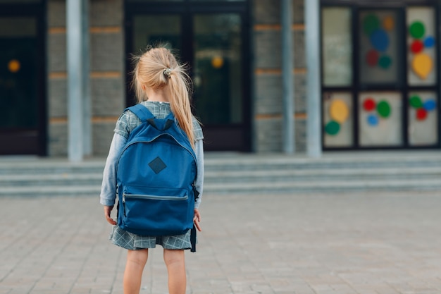 Petite fille mignonne avec le sac à dos retournant à l'école