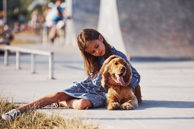 Une petite fille mignonne se promène avec son chien à l'extérieur par beau temps