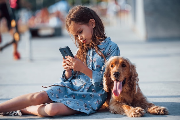 Une petite fille mignonne se promène avec son chien à l'extérieur par beau temps