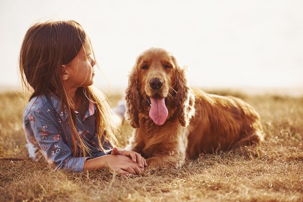 Une petite fille mignonne se promène avec son chien à l'extérieur par beau temps