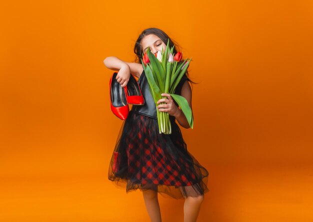 Petite fille mignonne tenant un bouquet de tulipes sur fond jaune Bonne journée de la femme Place pour le texte Émotions vives 8 mars