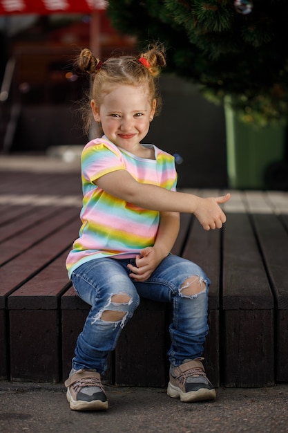 Petite fille à la mode en jeans et un t-shirt coloré