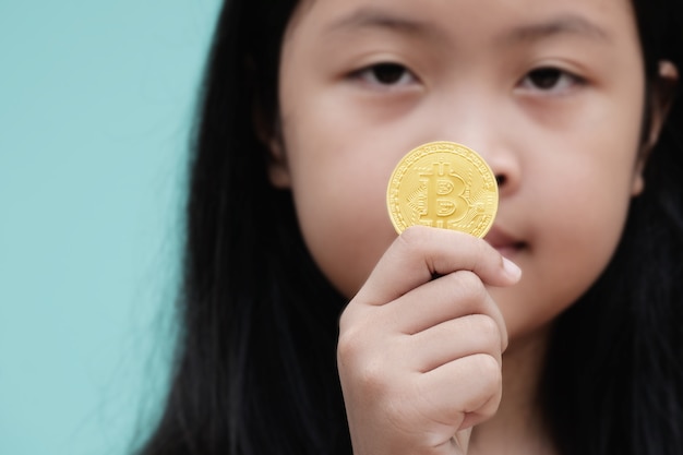 Petite fille montre or bitcoin en studio