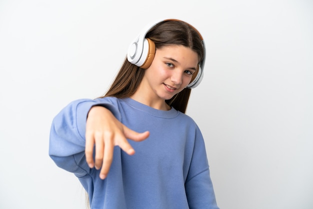 Petite fille sur mur blanc isolé, écouter de la musique