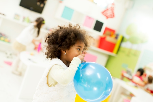 Photo petite fille noire avec un ballon