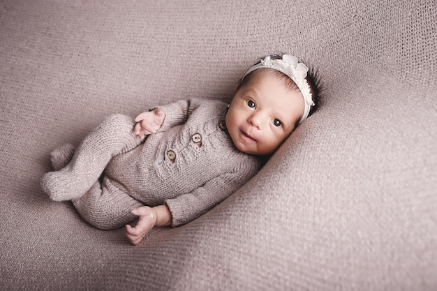 Une petite fille nouvellement née pose et sourit.