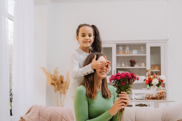 Une petite fille offre des fleurs à sa maman pour son anniversaire. fête des mères. bouquet de chrysanthèmes