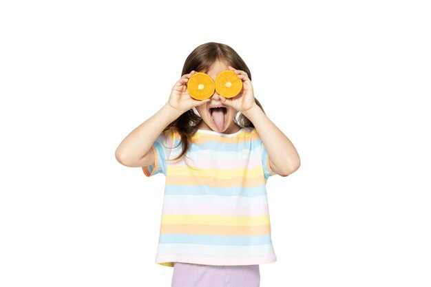 Petite fille avec des oranges dans les mains isolées sur fond blanc