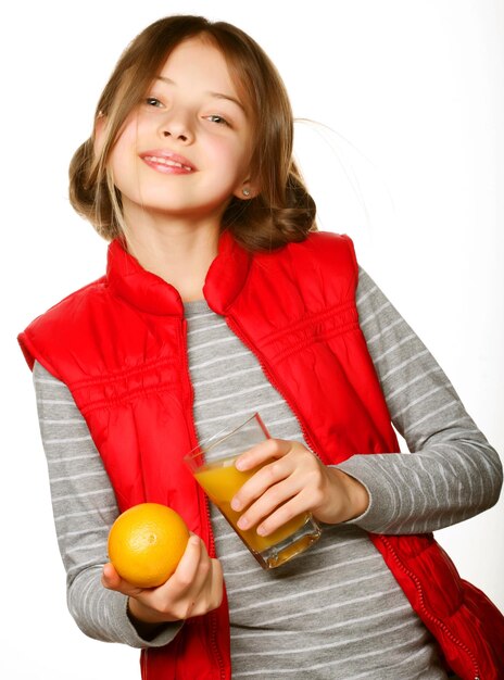 Petite fille avec des oranges et du jus