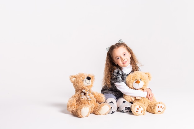 petite fille avec ours debout sur blanc