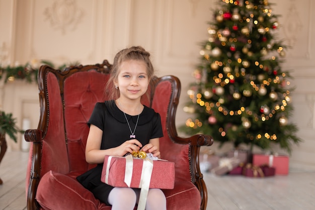 Une petite fille ouvre un cadeau de Noël du Père Noël