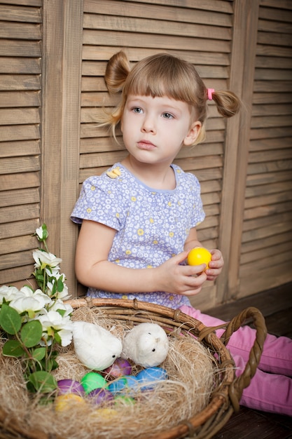 Petite fille avec panier plein d'oeufs colorés