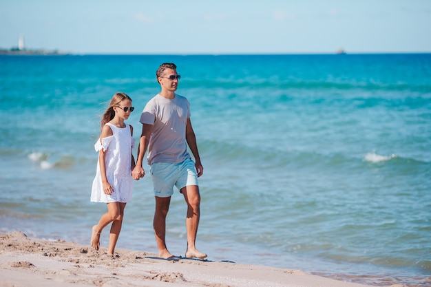 Petite fille et papa heureux s'amusant pendant les vacances à la plage