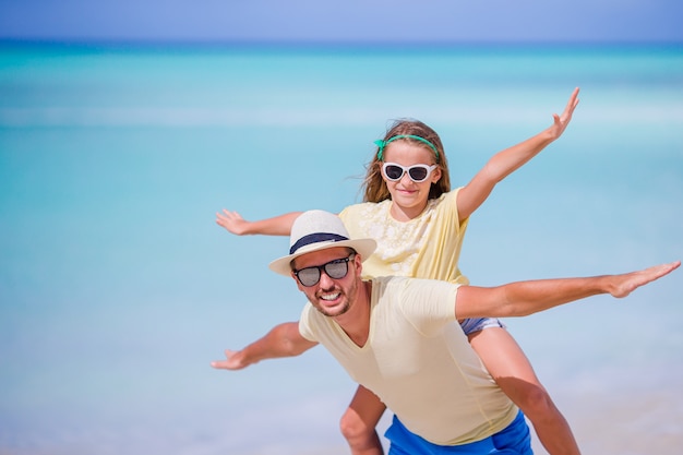 Petite fille et papa heureux s'amuser pendant les vacances à la plage