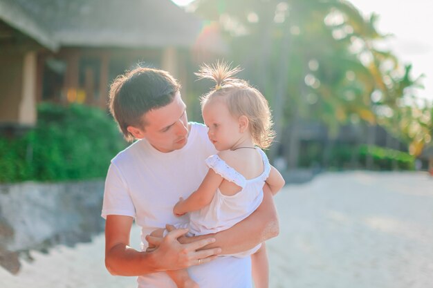 Petite fille et papa heureux s'amuser pendant les vacances à la plage