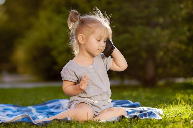 Petite fille parlant au téléphone dans le parc