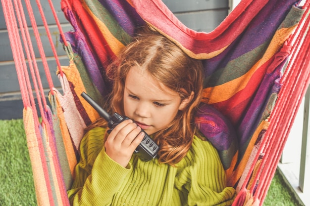 La petite fille parle à la radio par une journée d'été ensoleillée