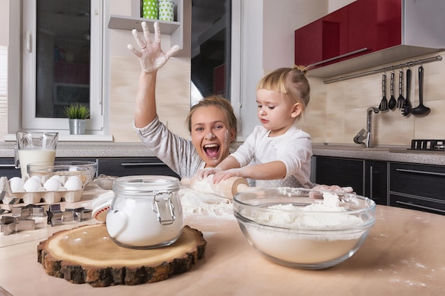 Une petite fille passe du temps avec sa mère dans la cuisine pour faire des biscuits