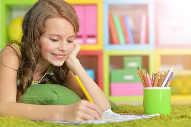 Petite fille peignant avec un crayon dans sa chambre