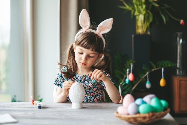 Petite fille peignant l'oeuf de pâques