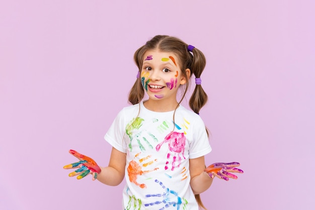 Une petite fille peinte avec des peintures multicolores devra créer de manière ludique sur un fond rose isolé Développement de la créativité des enfants pour les écoliers