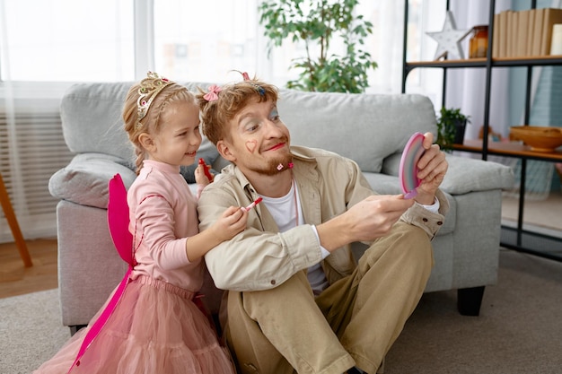 Petite fille et père heureux avec un maquillage drôle