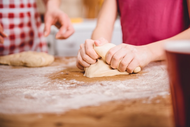 Petite fille à pétrir la pâte à pizza