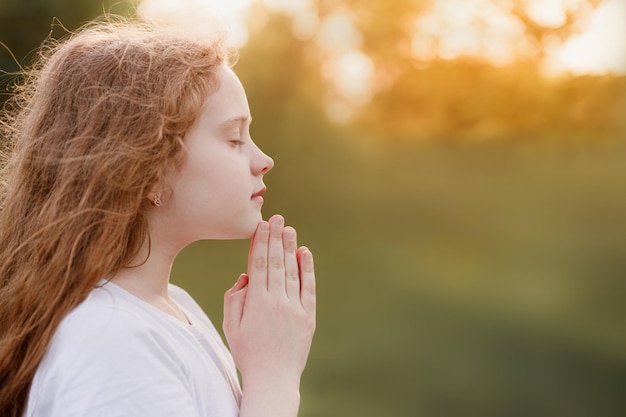 La petite fille a plié sa main en priant