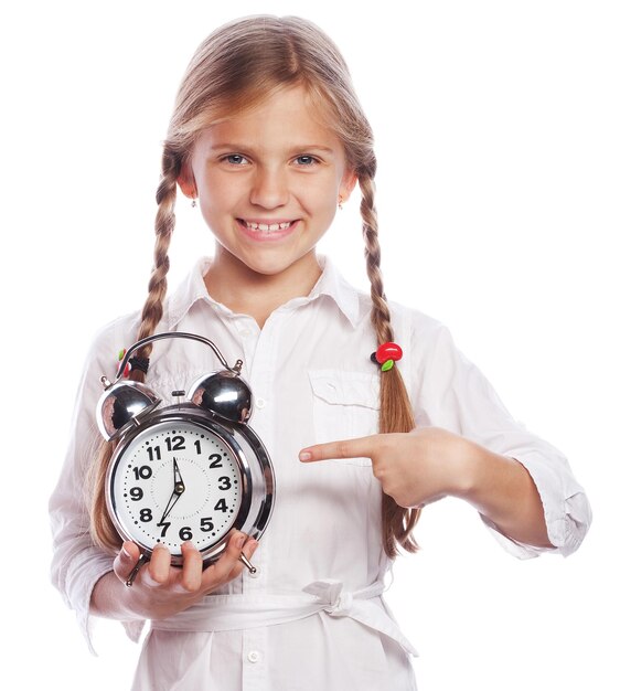 Petite fille pointant vers l'horloge apprenant à lire l'heure