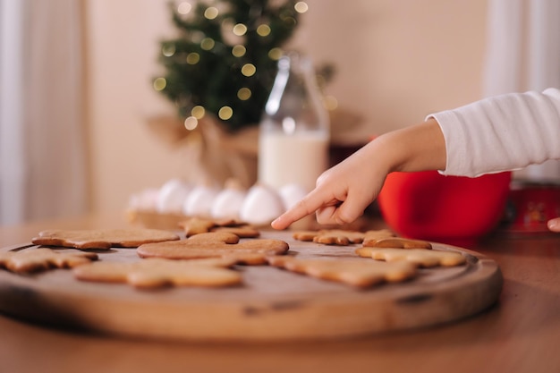 Une petite fille pointe du doigt la cuisson du pain d'épice de Noël à la maison