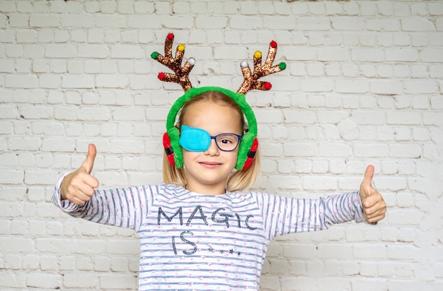 Petite fille portant occluder et cornes de cerf de Noël, traitement de l'amblyopie et mauvaise vue