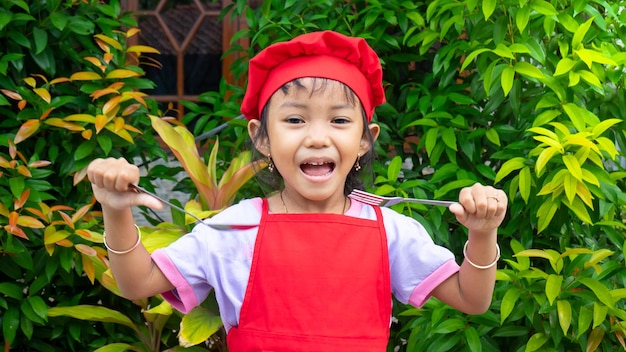 Petite fille portant des vêtements de cuisine rouges