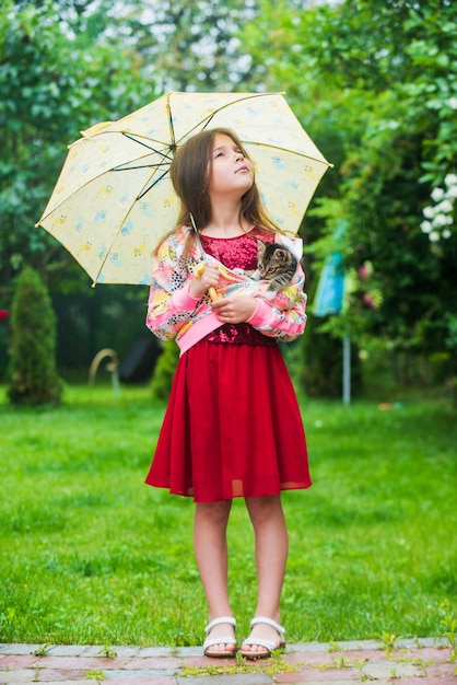 Petite fille porte un chat mignon chaton sous le concept de petit ami parapluie