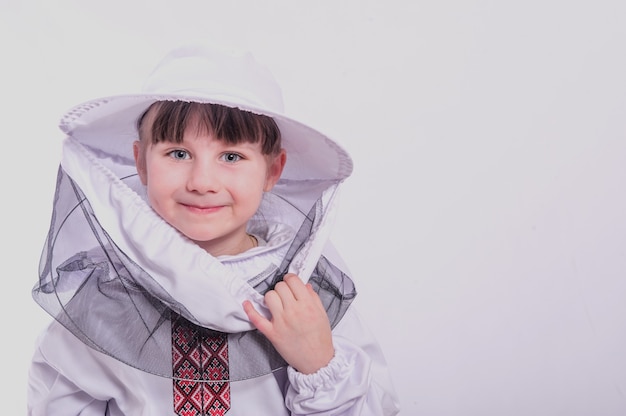 Une petite fille porte un costume d'abeille surdimensionné en studio sur fond blanc.