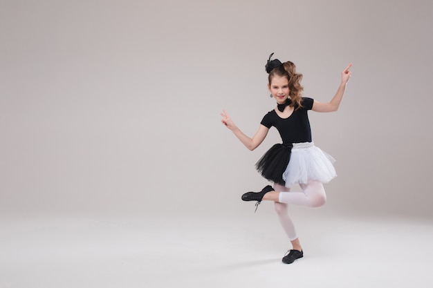 Petite fille posant avec sa jambe en costume de danse.